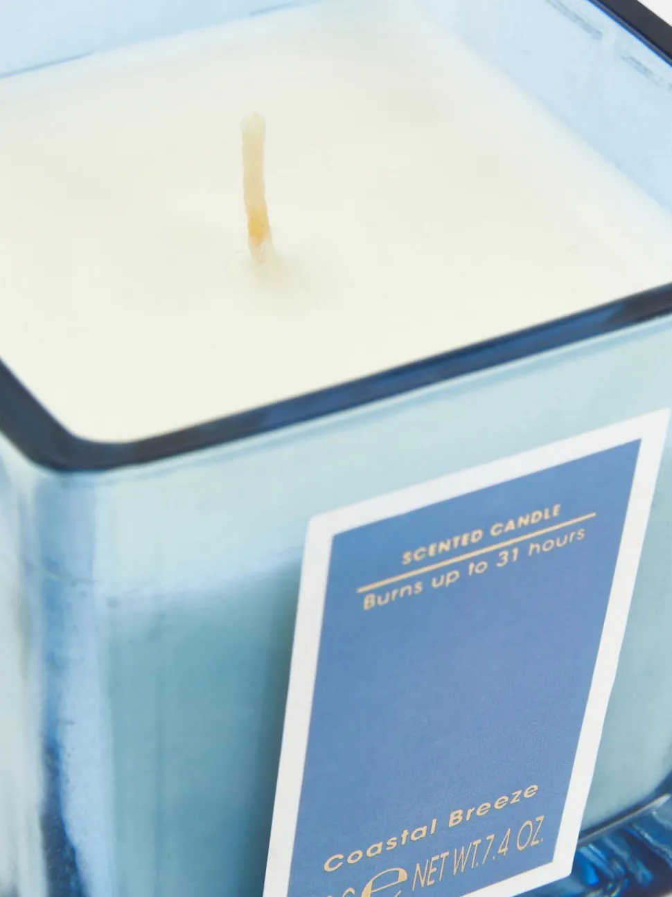 Świeca w kwadratowym pojemniku z barwionego szkła